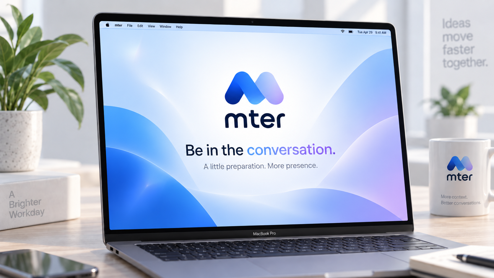 A quiet desk with a Mac displaying the mter logo and the words Be in the conversation.